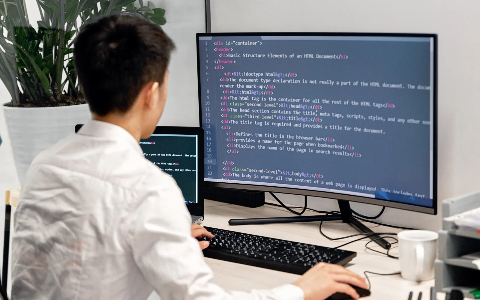 Developer reviewing code at a desktop workstation