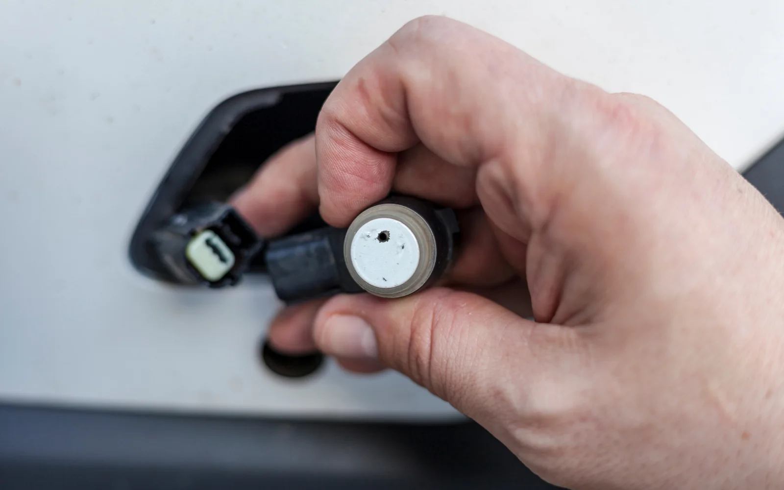 Technician handling a vehicle parking sensor