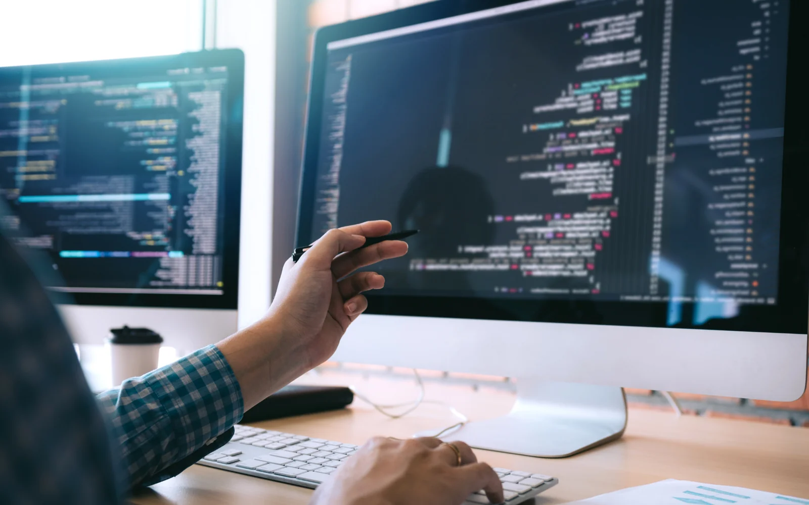 Developer discussing source code on a desktop display