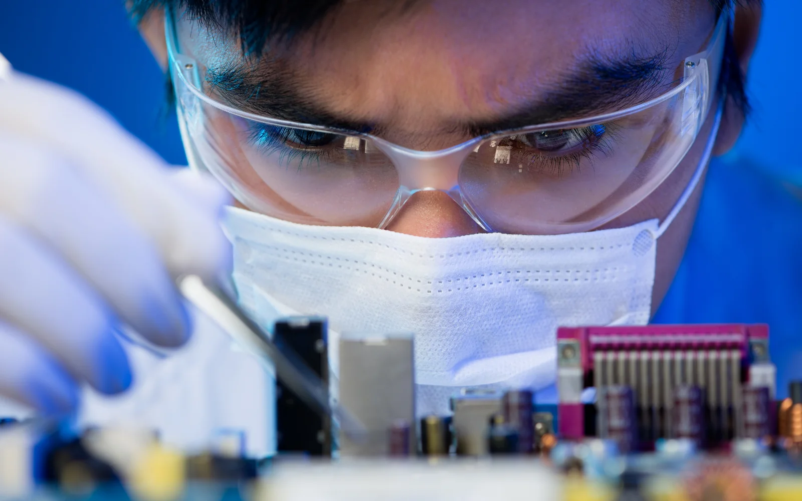 Engineer inspecting electronic hardware at a workbench